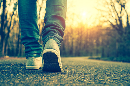 closeup of person's legs and shoes walking on street